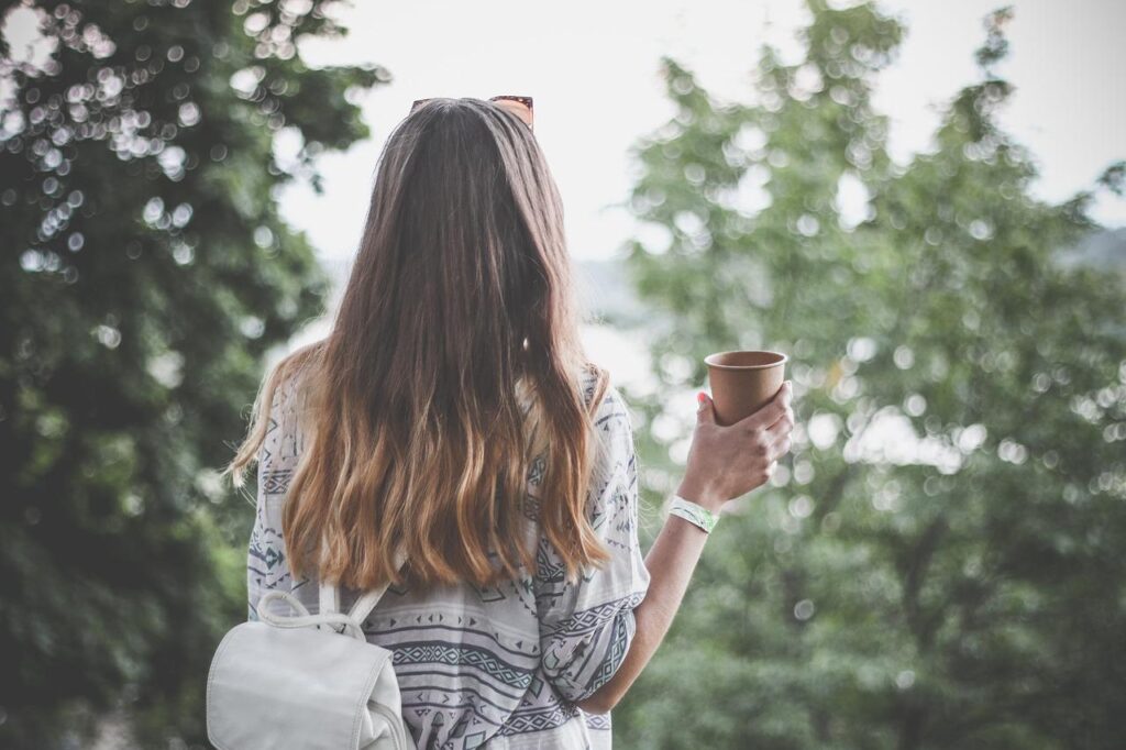 コーヒー片手に旅する女性